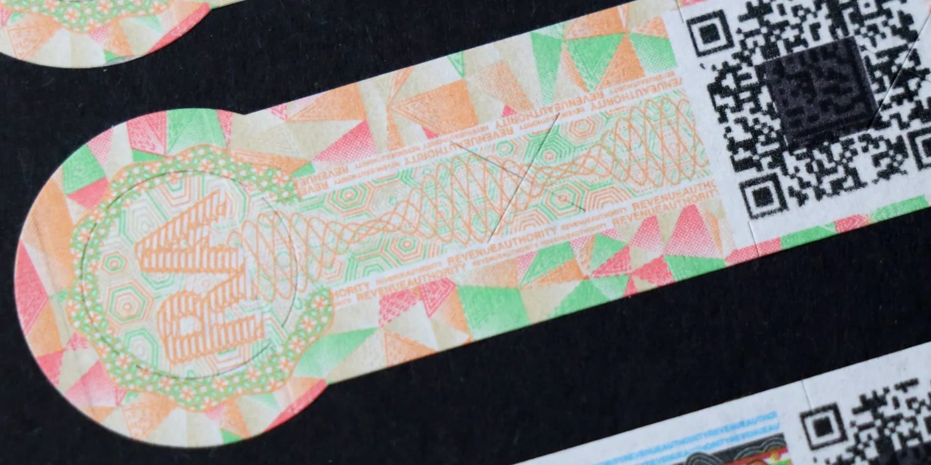 Security print in close-up, showing guilloché line work, microtext and a die-cut edge