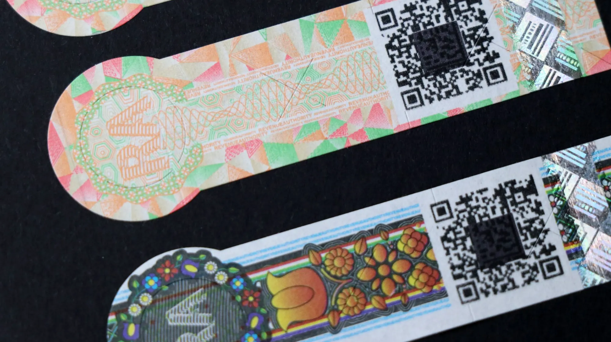A sheet of printed excise stamps, showing guilloché line work, colour-shifting inks and machine-readable codes